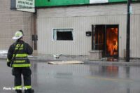 A firefighter with flames burning inside the building