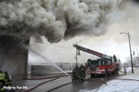 Firefighters direct a hose stream into the building