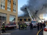 A view of aerial devices and smoke venting from the building