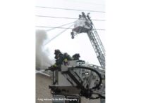 Two tower ladder buckets with firefighters administering streams