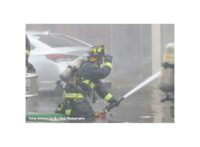 An Orlando firefighter directing a hose stream during fire suppression operations