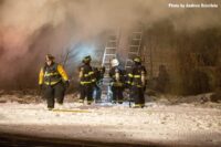 Firefighters operating in the snow at structure fire