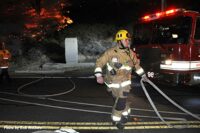 A Los Angeles firefighter flakes out a hoseline at the fire