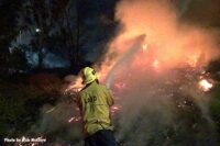 LAFD firefighter with hose applying water to fire