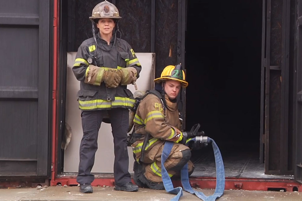 Katie Johnson and another firefighter with a hoseline