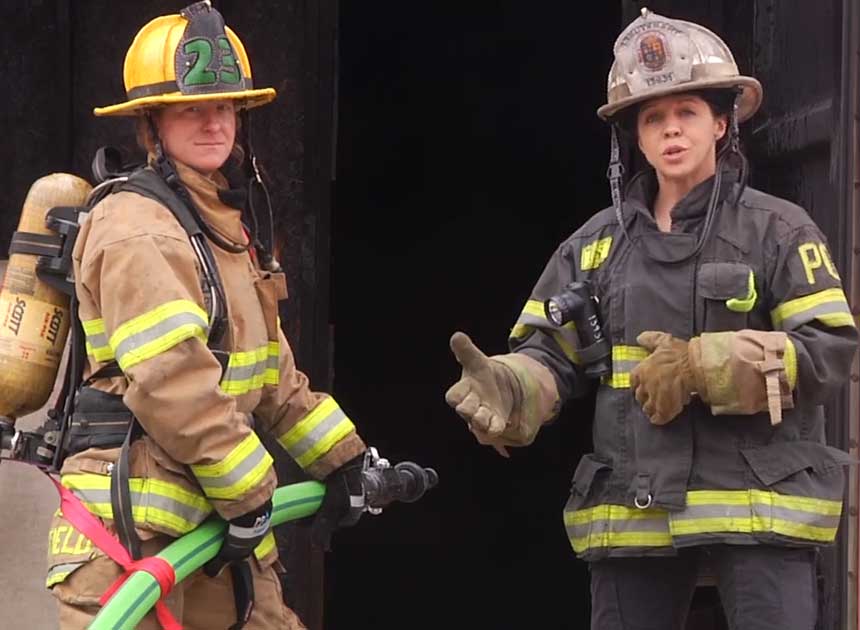 Katie Johnson and another firefighter using webbing for hoseline control