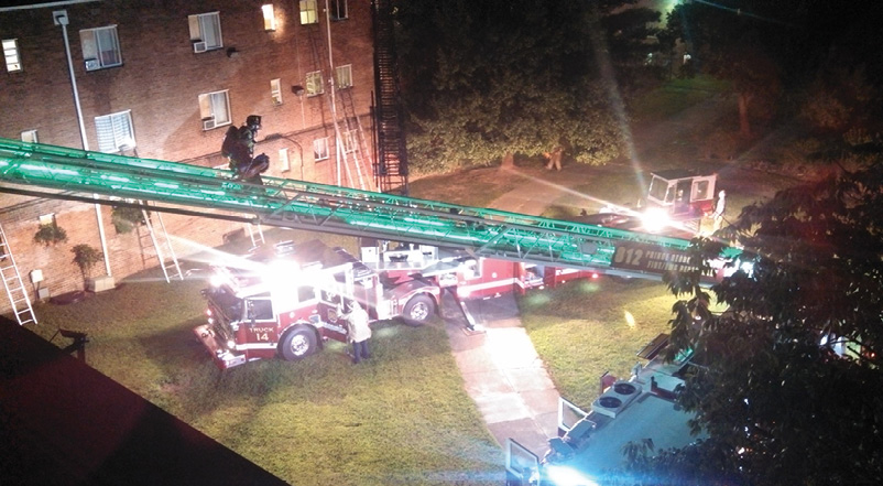 Although the two aerial apparatus are positioned on the grass at side C of this apartment fire, both have spotted the outriggers safely on the concrete sidewalk, saving personnel about 300 yards of travel and giving a well-lit working area for crews. (Photos by author unless otherwise noted.)