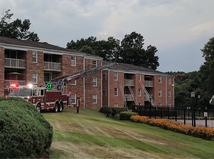 Positioned on side C of an apartment fire, this truck backed in and was able to reach the apartment building’s roof. As a result, the ladder bed was closer to the building and it was easier to get ladders in place. Even with uneven topography, they could navigate through the grass and gain access to the building.