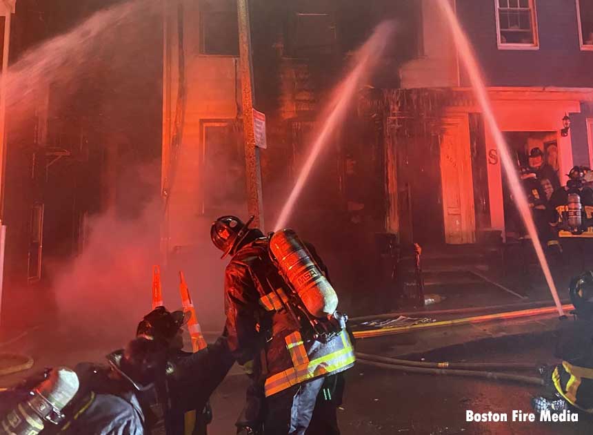 Boston firefighters operate a hoseline on the exterior of the building