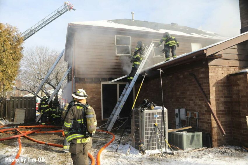 A view of firefighters and various ladders on the fireground