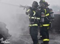 Firefighters aim a hoseline at the tanker