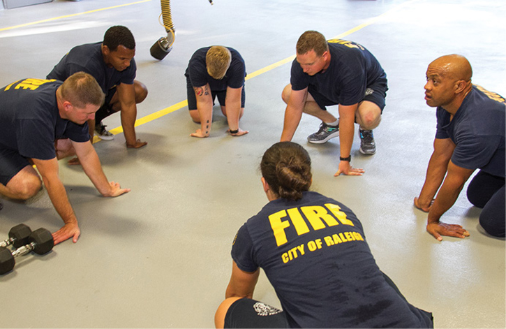 Firefighters work on range of motion and flexibility as a cool-down to an exercise session.