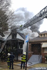 Aerial ladder directed to roof of burning building