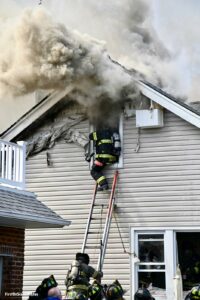 A firefighter makes a window form a ground ladder