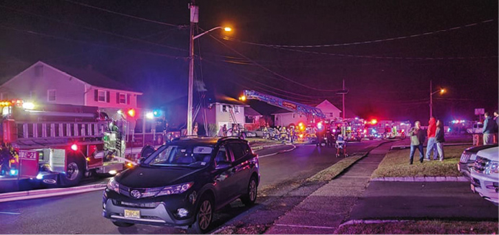 An overview of the fireground operation, including the placement of the ladder truck with the body directly under the communication wires. Positioning the ladder truck in this manner sometimes takes the hazard of the overhead wires out of the equation. Truck operators must always exercise caution around overhead obstructions.