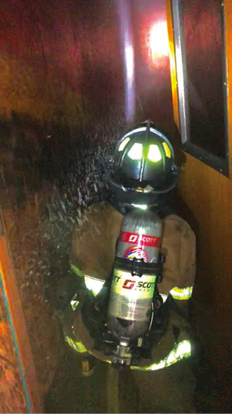 A student flows water at the burn room door.