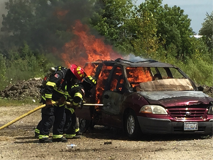 Firefighters attack a vehicle fire