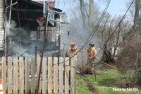 Firefighters administer water on the exterior of the fire