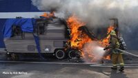 Flames shoot from the trailer as LAFD firefighters work