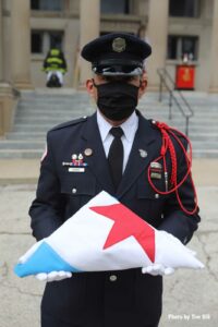 In a mask due to the coronavirus, a Chicago firefighter at the funeral