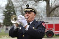 Firefighter playing a horn at the funeral