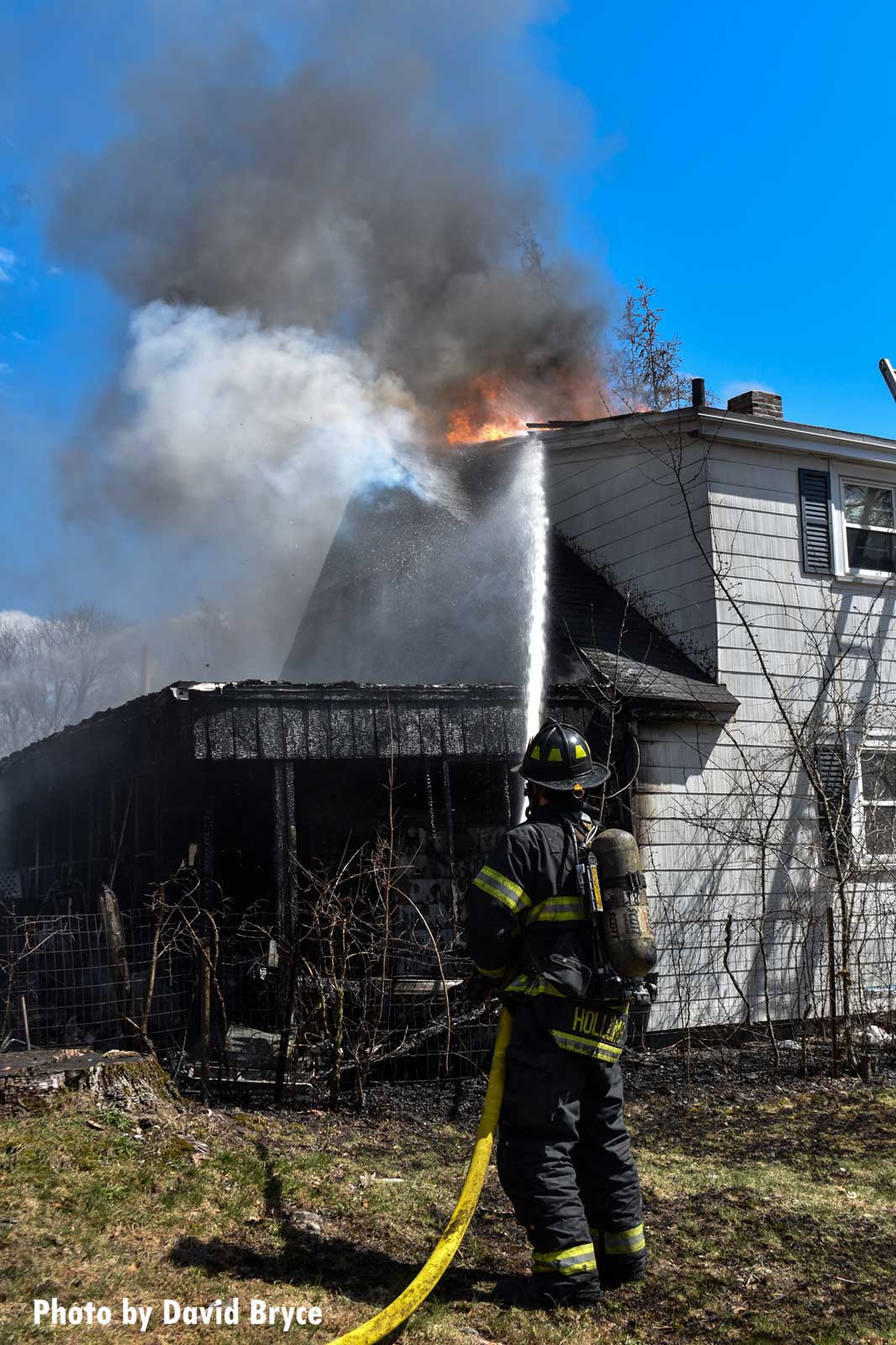 A firefighter puts a hoseline on the building's roof