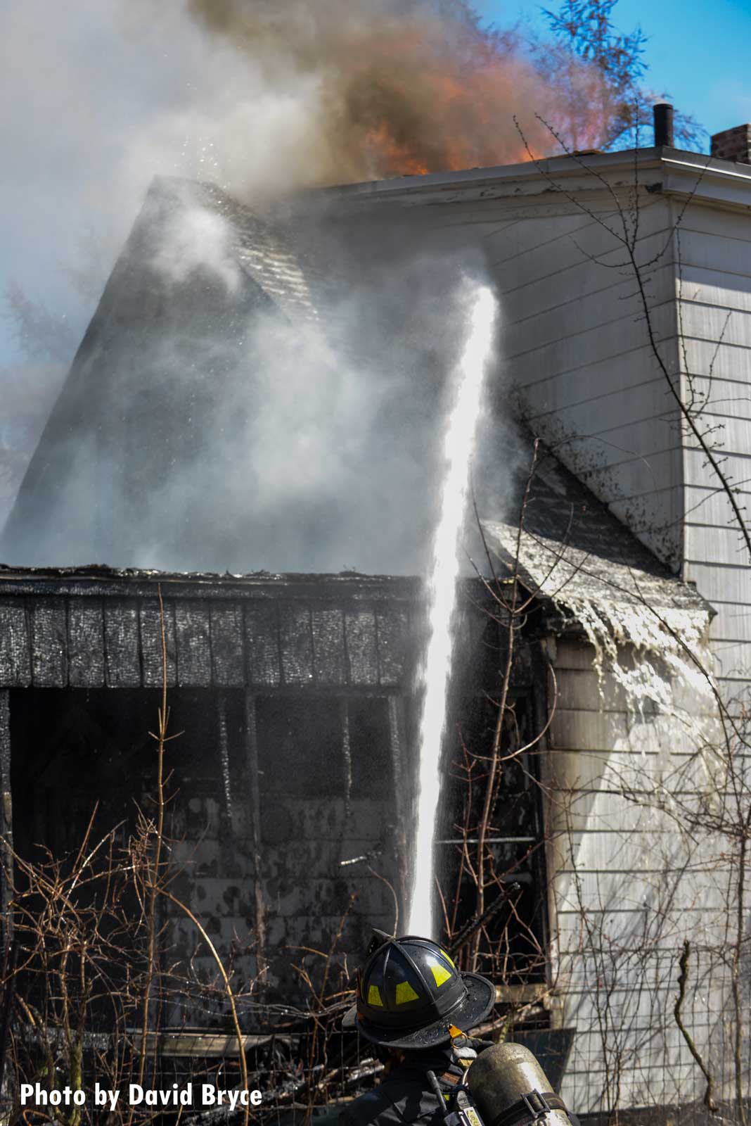 Firefighter directs a stream on the roof of the building