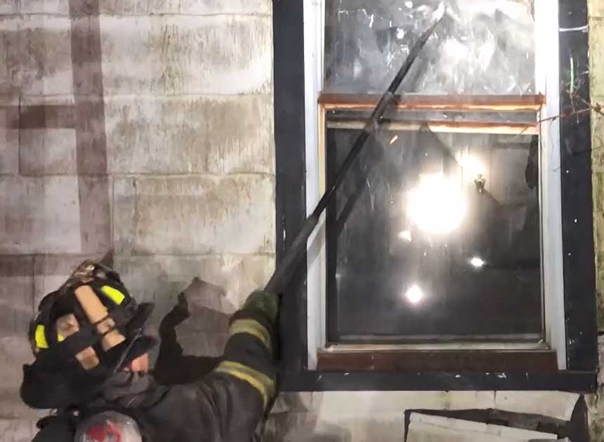 Firefighter taking the window with a hook