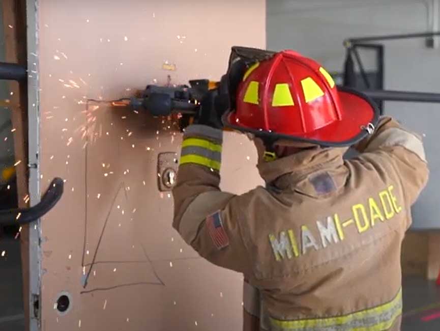 A Miami-Dade firefighter cuts a door with a Mul-T-lock