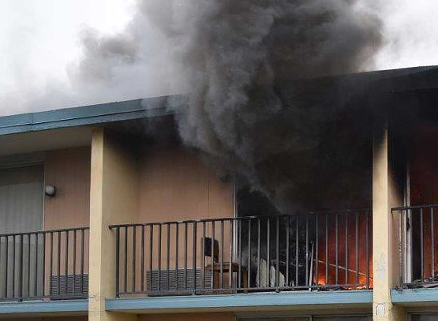 Smoke billows from a balcony