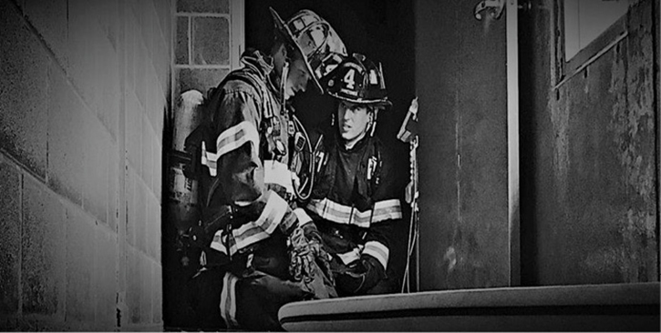 Two modern firefighters contemplate the delicate balance between tradition and innovation.