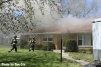 Firefighters arrive on scene with smoke showing from home