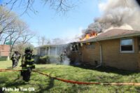 Firefighters move hose at the Northbrook house fire