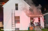 Firefighter raise a ladder at a house fire