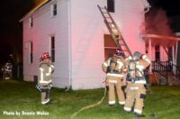 Firefighters with a ladder at a Royal Oak house fire