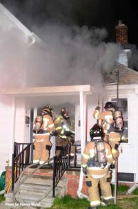 Firefighters at the door during a house fire with smoke