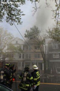 Firefighters working at the smoke-filled fire scene