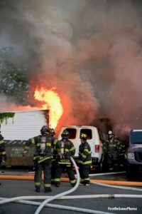 Firefighters with a hoseline responding to the structure fire