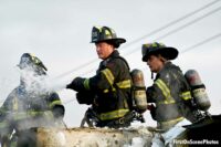 Firefighters maneuver a hose stream