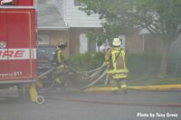 Firefighters pull lines at the house fire