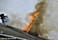 Flames shoot through the roof of the home