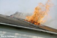 Flames vent from the roof during the Moonachie house fire