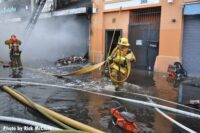 A firefighter moving hose at the explosion