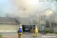 A smoke conditions rises from the buildings as firefighters work