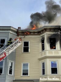 Firefighter in a an aerial continues to battle hot spots hours after the fire