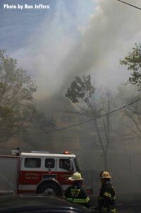 A fire truck with smoke rising from the structure