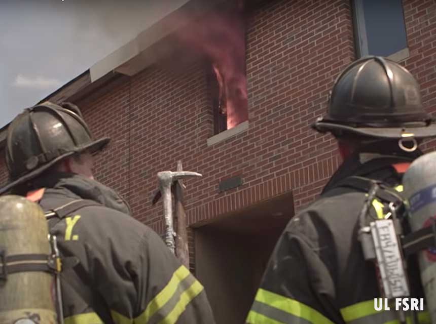 Firefighters looking at fire venting through a window