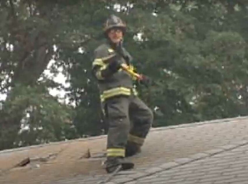 Mike Ciampo on the roof holding an ax