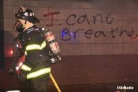 Firefighter with I Can't Breath graffiti on wall