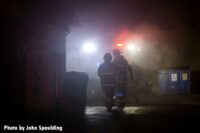 Firefighters navigating through the haze of the fire scene